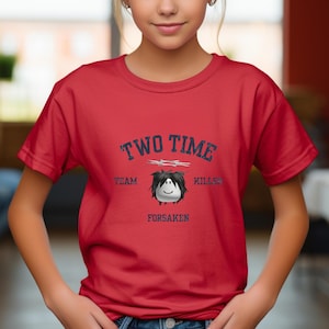 May include: Red t-shirt with the text "TWO TIME KILLER" in navy blue, along with the words "TEAM" and "FORSAKEN". A cartoon character with black hair and a smiling face is in the center of the design.