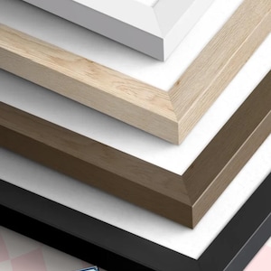 May include: Close-up of four picture frames in white, light wood, brown, and black. The frames are angled, showcasing their different colors and textures. The frames are on a white background. The Cassette Collective logo is in the bottom left corner.