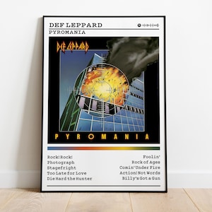 Könnte beinhalten: Gerahmtes Poster des Def Leppard Albums "Pyromania". Das Artwork zeigt ein Gebäude mit einem Ziel, das Logo der Band und den Albumtitel. Songtitel sind unter dem Bild aufgeführt, in einem schwarzen Rahmen.