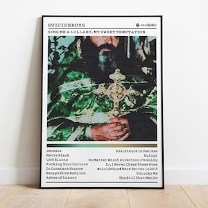 May include: A framed poster featuring the text "SUICIDEBOYS" and "SING ME A LULLABY, MY SWEET TEMPTATION." The image shows a person holding a cross. The poster includes a list of song titles. The color scheme is green, gold, and black.