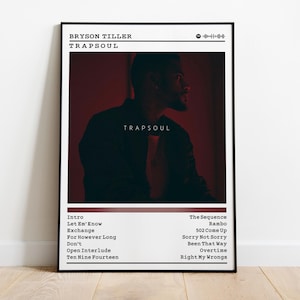 May include: A framed poster featuring Bryson Tiller's album "Trapsoul." The poster has a black frame and a red and black color scheme. The album title and artist name are at the top, with a photo of a person in the center. The tracklist is at the bottom.