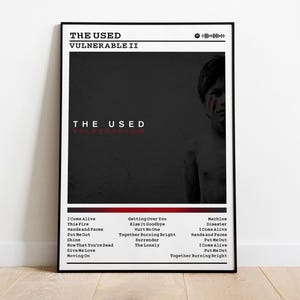 May include: A framed poster featuring the band "The Used" and the album title "Vulnerable II". The poster has a black and red color scheme with a grayscale image of a person. The tracklist is listed at the bottom.