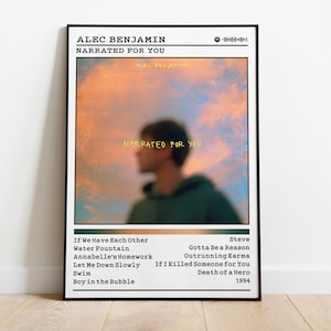 Puede incluir: Un póster enmarcado con la portada del álbum "Narrated for You" de Alec Benjamin. La obra de arte presenta una imagen borrosa de una persona con una sudadera con capucha verde contra un cielo colorido. El título del álbum y el nombre del artista están en la parte superior.