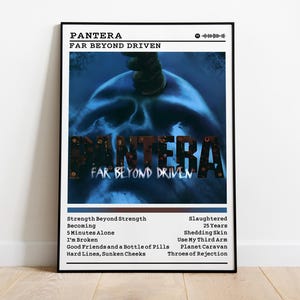 May include: A framed poster featuring the album art for Pantera's "Far Beyond Driven." The artwork displays a skull with a dark blue hue, with the band's name and album title prominently displayed. The poster includes a tracklist.
