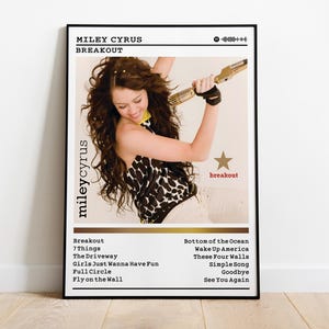 May include: A framed poster of Miley Cyrus's "Breakout" album cover. The image shows Miley holding a gold microphone. The poster includes the album title, tracklist, and a star graphic with the word "breakout".