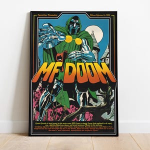 以下が含まれることがあります： MF DOOMのコミックイラストが描かれた額入りのポスター。アートワークは、銀色の鎧を着た緑色のフードをかぶった人物が手を伸ばしている様子を描いています。ポスターは黒い縁取りで、「MF DOOM」の文字が大きくオレンジ色と黄色で書かれています。
