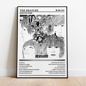 May include: Black and white poster featuring the album art for The Beatles' "Revolver." The artwork includes portraits of the band members and the album title. Song titles are listed below the image. The poster is framed in a black frame.