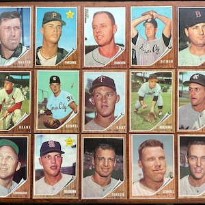 May include: A collection of fifteen vintage baseball cards arranged in a grid, each featuring a portrait or action shot of a player in a team uniform, with names and team affiliations printed at the bottom of each individual card.