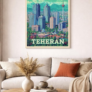 以下が含まれることがあります： イランのテヘランの額入りアートプリント。高層ビル、山、緑色の「TEHERAN」の文字が描かれた都市景観。 プリントは、装飾的な枕と木製のコーヒーテーブルのあるソファの上に表示されています。