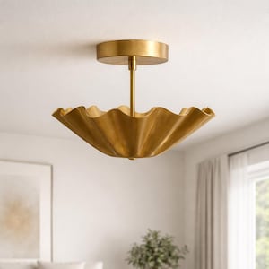 Könnte beinhalten: Eine goldfarbene Deckenleuchte mit einem gerüschten, gewellten Schirm. Das Licht wird von einer runden Deckenhalterung durch eine schlanke Stange abgehängt. Die Leuchte hat eine warme Metalloptik und verleiht dem Raum einen Hauch von Eleganz.