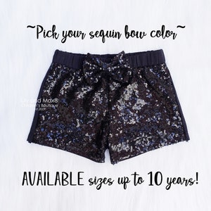May include: Black sequin shorts with a black bow and black trim. The shorts are available in sizes up to 10 years. "Pick your sequin bow color" is written above the shorts.