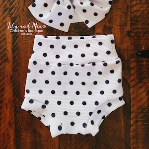 May include: White polka dot baby bloomers with a matching white polka dot headband. The headband is tied into a large bow.