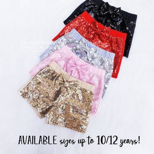 May include: A set of six sequined shorts with bows in various colors, including black, red, silver, pink, and gold. The shorts are available in sizes up to 10/12 years. "Pick your sequin bow color" and "AVAILABLE sizes up to 10/12 years!" are written on the image.