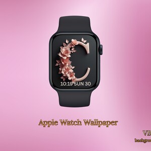 May include: Black Apple Watch featuring a rose gold floral "C" design on the watch face. The time and date are displayed. The words "Apple Watch Wallpaper" are at the bottom of the image.