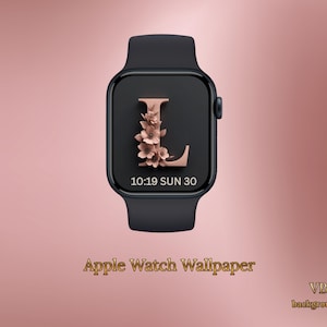 May include: Black Apple Watch featuring a rose gold floral "L" design on the screen. The watch face shows the time and date. The words "Apple Watch Wallpaper" are at the bottom of the image.