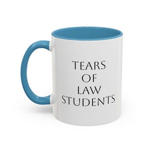 May include: White ceramic mug with a blue interior and handle. The mug features the text "TEARS OF LAW STUDENTS" in black, centered on the front. The mug is designed for hot beverages.