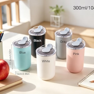 May include: Five insulated tumblers in blue, black, white, gray, and pink, each with a flip-top lid. The tumblers are 4.52 inches tall and 2.95 inches wide, with a capacity of 10 oz. Text on the tumblers indicates their color. An apple, pencils, and a notebook are also visible.