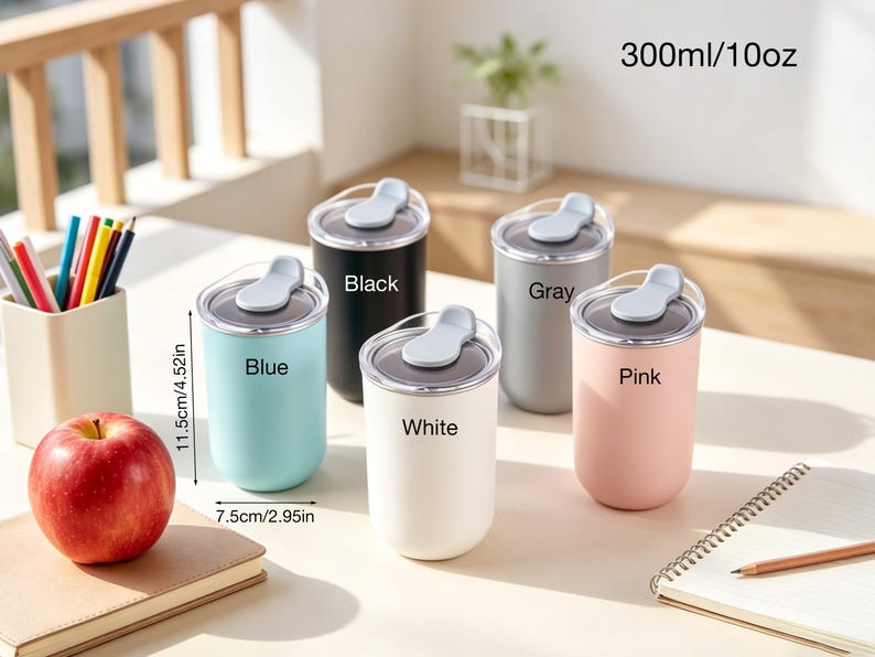 May include: Five insulated tumblers in blue, black, white, gray, and pink, each with a flip-top lid. The tumblers are 4.52 inches tall and 2.95 inches wide, with a capacity of 10 oz. Text on the tumblers indicates their color. An apple, pencils, and a notebook are also visible.