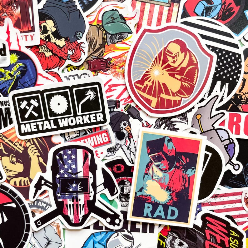 May include: A collection of colorful stickers featuring metal worker themes. Designs include skulls with welding helmets, the American flag, and the text "METAL WORKER" and "RAD". The stickers are in various shapes and sizes, with a mix of bold colors and graphic illustrations.