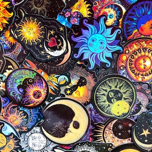 May include: A collection of celestial-themed stickers featuring suns, moons, and stars in various colors. The stickers have intricate designs with detailed illustrations and a mystical aesthetic. The color palette includes blues, oranges, yellows, and purples, creating a vibrant and eye-catching assortment.