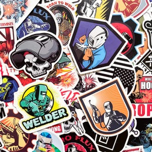 May include: A collection of colorful stickers featuring welding-themed designs. The stickers showcase images of welders, welding tools, skulls, and text like "BORN TO WELD" and "WELDER". The stickers are in various shapes and sizes.
