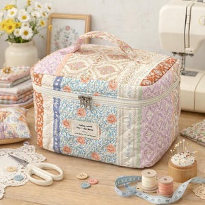 Może przedstawiać: Biały ceramiczny kubek z czarnym uchwytem i napisem "But First, Coffee" pogrubioną, czarną czcionką. Kubek stoi na drewnianej powierzchni. Kubek ma około 10 cm wysokości.