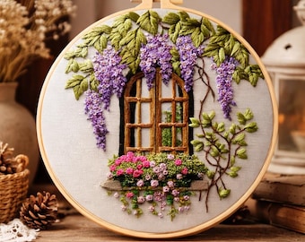 May include: Embroidered hoop art featuring a window scene with wisteria and flowers. The design includes a wooden window frame, purple wisteria blooms, and a window box filled with pink and red flowers. The embroidery is set in a wooden hoop.