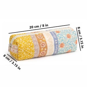 May include: A cylindrical pencil case, 8 inches long and 3.15 inches in diameter, with a zipper closure. The case features a patchwork design with floral and lace patterns in yellow, brown, blue, and white. The case is 8 inches long and 3.15 inches in diameter.