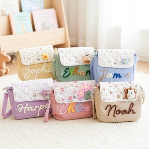 May include: A collection of corduroy crossbody bags in various colors, each with a quilted flap and personalized name. The bags feature floral or animal embellishments and are designed for children. The names include "Sophie", "Ethan", "James", "Harper", "Chloe", and "Noah".