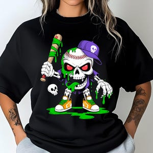 May include: Black t-shirt featuring a cartoon skeleton baseball player with a baseball bat. The skeleton wears a purple baseball cap and orange sneakers. Green slime drips from the skeleton's head and hands. A small skull is also present.