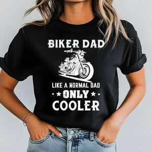 Puede incluir: Camiseta negra con un gráfico blanco de una motocicleta y el texto "BIKER DAD LIKE A NORMAL DAD ONLY COOLER". La camiseta está hecha de un material suave y es adecuada para uso casual.