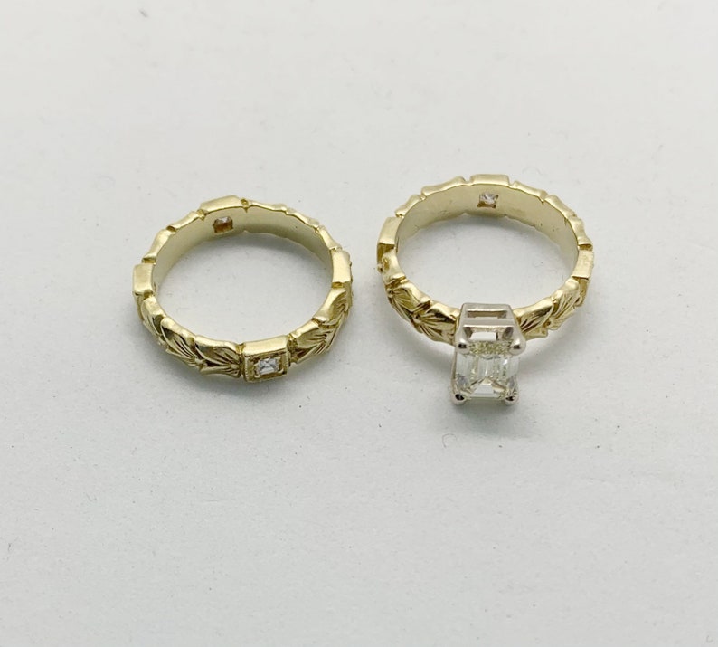 May include: A pair of gold wedding bands with intricate leaf designs. The band on the right has a square-shaped diamond set in the center.