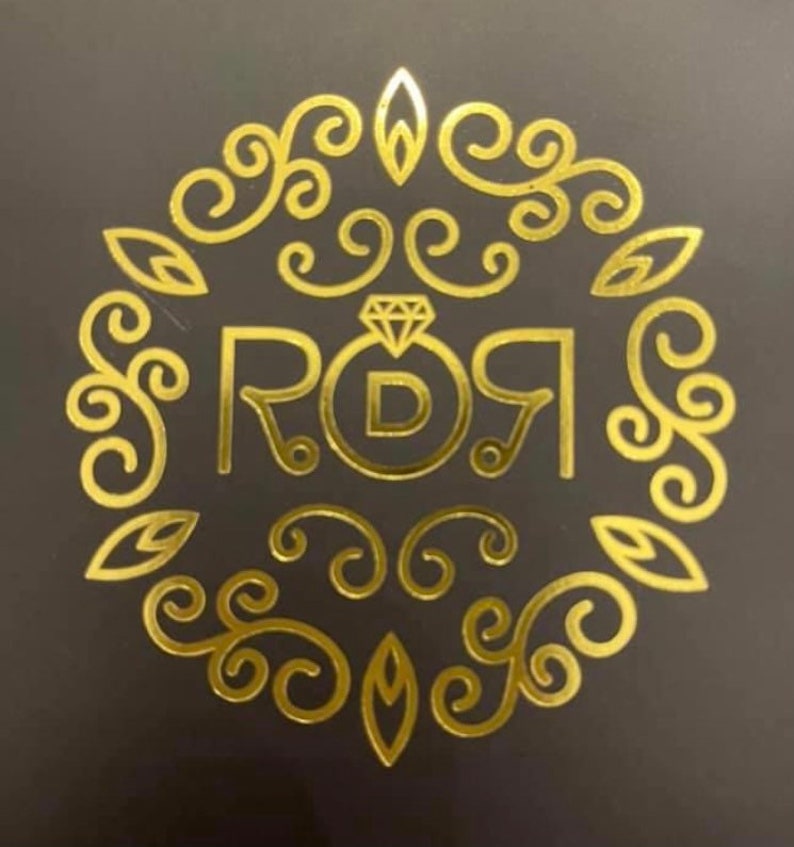 May include: A gold-colored logo with a diamond ring and the text "ROI" with a "D" in the center of the ring.