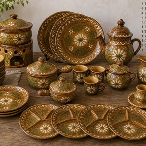 May include: A complete ceramic dinnerware set with a daisy floral design in brown and green. The set includes plates, bowls, serving dishes, a teapot, and cups. The set is ideal for a rustic or farmhouse-style kitchen.
