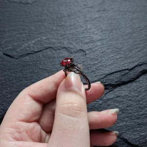 Anello di fidanzamento gotico con rubino: montatura floreale a loto nero, fascia Dark Romance