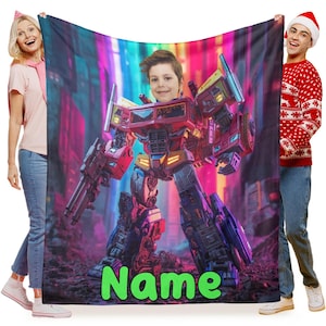 Könnte beinhalten: Eine personalisierte Decke mit einer lebendigen Illustration eines Roboters mit dem Gesicht eines Kindes. Der Roboter ist überwiegend rot, blau und gelb, vor einem farbenfrohen Stadtbildhintergrund. Das Wort "Name" steht grün am unteren Rand.