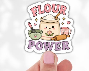 May include: A die-cut sticker featuring a cute anthropomorphic bag of flour with a smiling face, surrounded by a whisk, a green bowl, a rolling pin, and a measuring cup. The text FLOUR POWER is printed in pink and purple letters above and below.