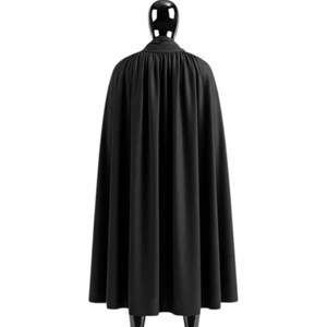 Może przedstawiać: Czarny płaszcz z wysokim kołnierzem i płynnym designem. Peleryna jest prezentowana na manekinie, prezentując całą jej długość i drapowanie. Tkanina wydaje się być matowym materiałem.