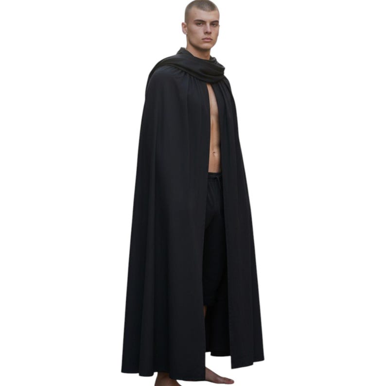 Może przedstawiać: Długi, czarny płaszcz z drapowanym kołnierzem. Peleryna sięga do ziemi i jest wykonana z zwiewnej tkaniny. Osoba ma na sobie czarne spodnie. Tło jest jednolicie białe.