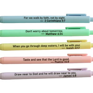 May include: Five pastel-colored pens with inspirational quotes. The pens are light blue, green, yellow, peach, and lavender. Each pen has a different quote in black text, such as "For we walk by faith, not by sight."