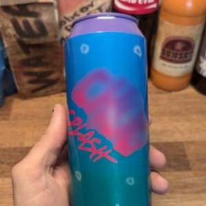 May include: A cylindrical can with a blue and teal gradient background, featuring a pink and purple splash design and the word "SPLASH" in pink. The top and bottom rims are purple.