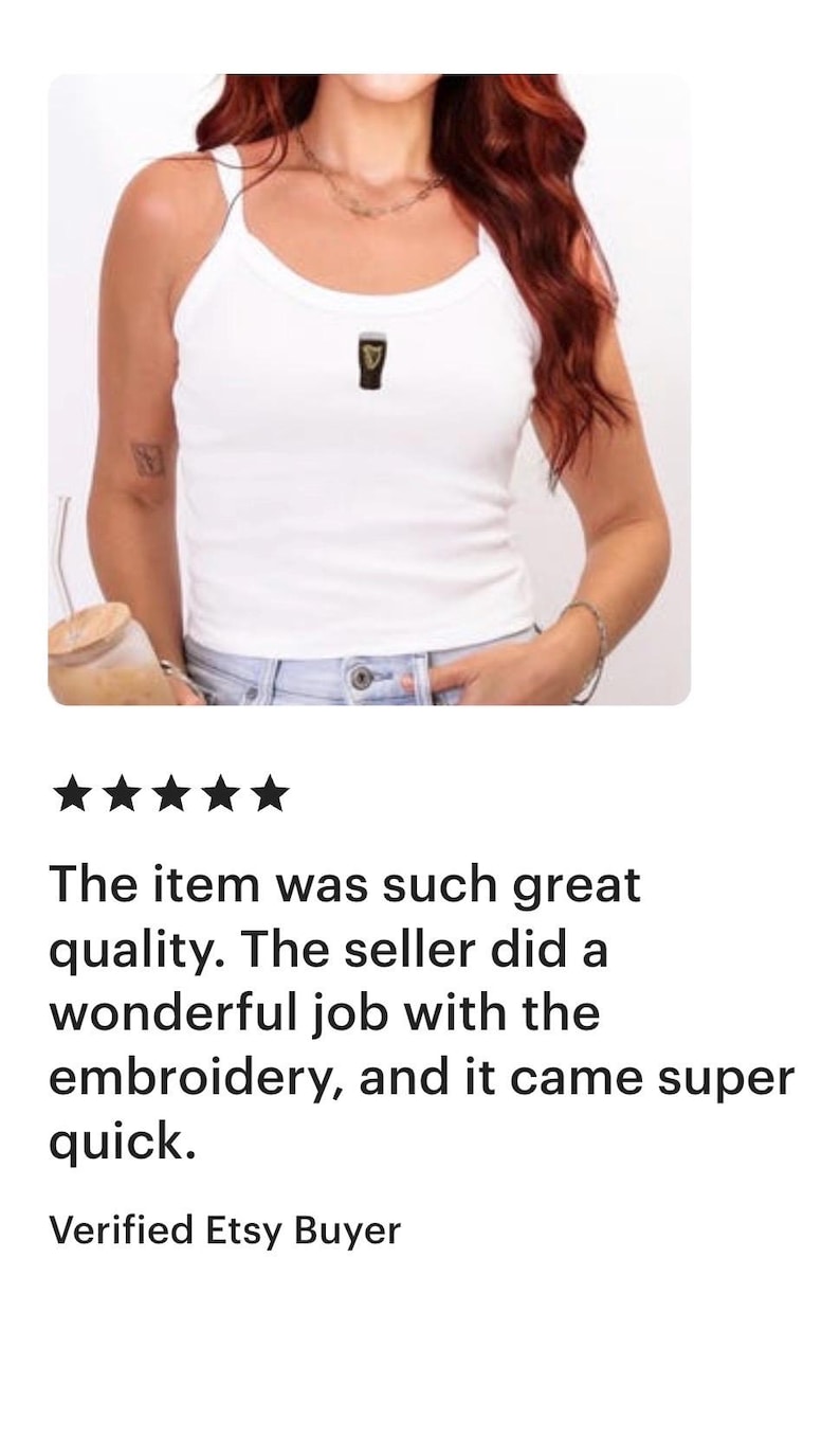 May include: White ribbed vest top with a small embroidered design. The top has thin straps and a scoop neckline. The image also includes a review of the item.