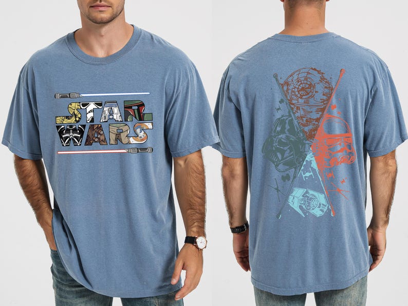 K&ouml;nnte beinhalten: Blaues T-Shirt mit dem Schriftzug "STAR WARS" in einer farbenfrohen, stilisierten Schriftart mit Lichtschwertern. Auf der R&uuml;ckseite des Shirts befindet sich eine Grafik von Star Wars-Charakteren und -Symbolen in Blau-, Orange- und Gr&uuml;nt&ouml;nen.