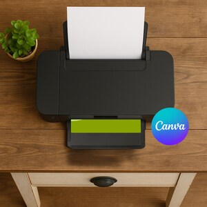May include: A black inkjet printer with a white sheet of paper in the paper tray. The printer is on a wooden desk with a small potted plant and a drawer. The Canva logo is visible on the right side of the image.