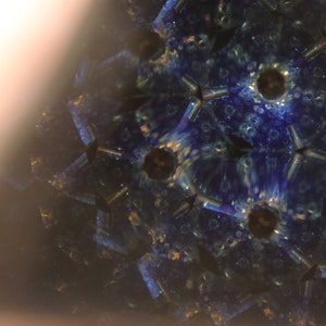 Pu&ograve; includere: Un'immagine di caleidoscopio con un motivo blu, verde e oro. L'immagine &egrave; simmetrica e ha una forma a stella.