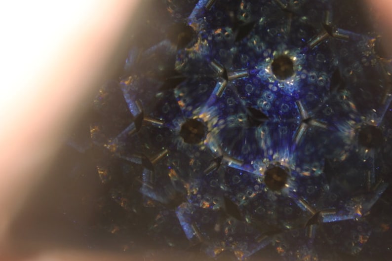 Pu&ograve; includere: Un'immagine di caleidoscopio con un motivo blu, verde e oro. L'immagine &egrave; simmetrica e ha una forma a stella.