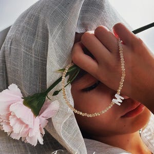 May include: A white ceramic mug with a black handle and the text "But First, Coffee" in a black, handwritten-style font. The mug is on a white surface.