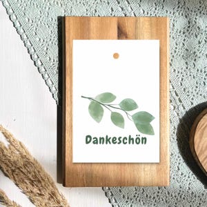 Könnte beinhalten: Ein Set aus drei Keramikbechern mit gesprenkelter, matter Oberfläche. Die Becher sind in den Farbtönen Creme, Hellgrau und Dunkelgrau gehalten. Jeder Becher hat ein schlichtes, minimalistisches Design und einen abgerundeten Henkel.
