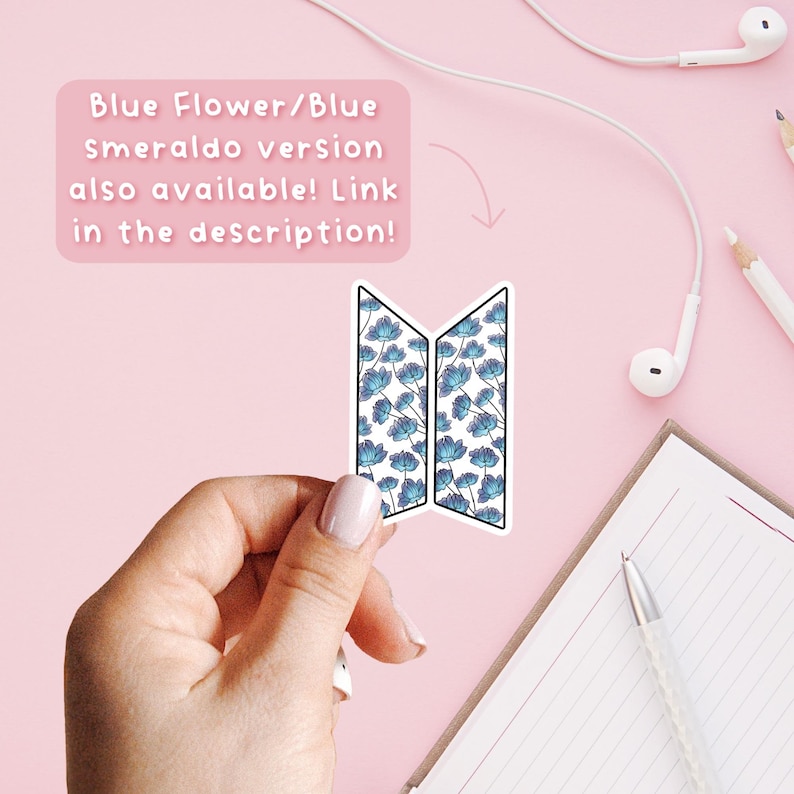 Może przedstawiać: Naklejka z niebiesko-białym kwiatowym wzorem, trzymana na r&oacute;żowym tle. Obraz zawiera tekst: "Blue Flower/Blue Smeraldo version also available! Link in the description!" Widoczny jest r&oacute;wnież notatnik i słuchawki.