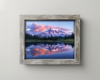May include: A framed landscape print featuring a mountain range reflected in a lake. The sky is filled with pink and orange clouds. The frame is made of weathered gray wood, adding a rustic touch to the artwork.